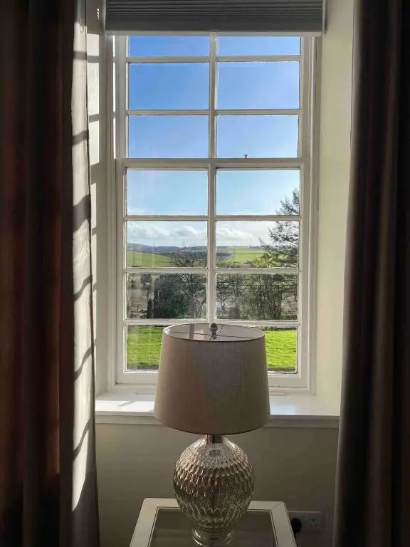 a vase sitting on a table in front of a window at 2 bedroom Townhouse within Grade C listed Ladysbridge House 2 night minimum stay in Ladysbridge Station