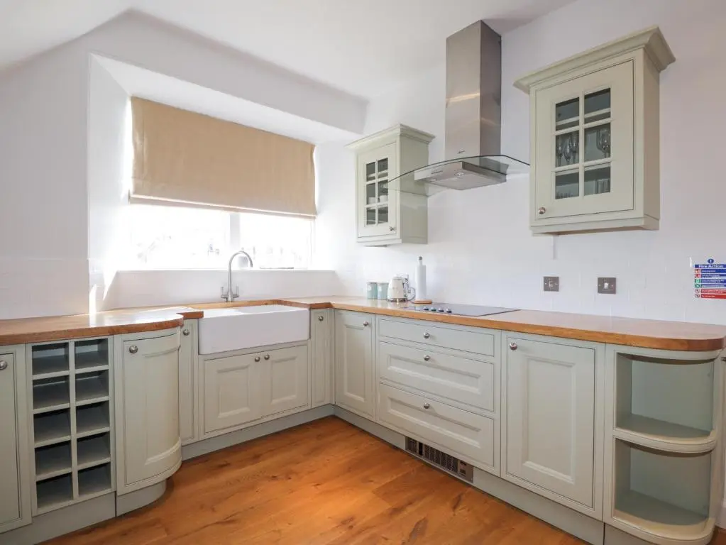 a kitchen with white cabinets and a sink at Aspen Spa Apartment in Dornoch