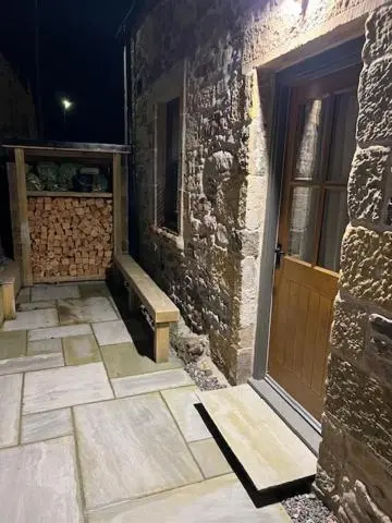 a stone building with a door and a stone floor at Balnain Street Cottage in Inverness
