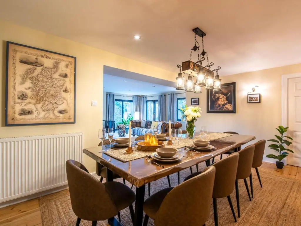 a dining room with a large wooden table and chairs at Villa Drover's Lodge by Interhome in Drumnadrochit
