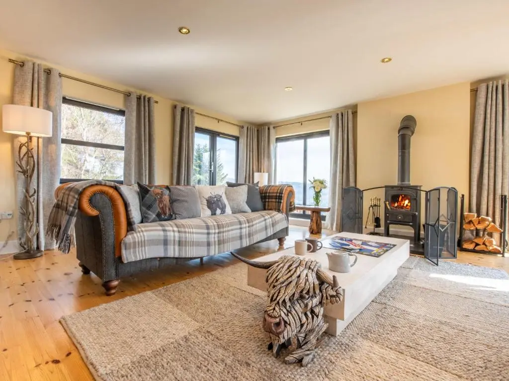a living room with a couch and a fireplace at Villa Drover's Lodge by Interhome in Drumnadrochit