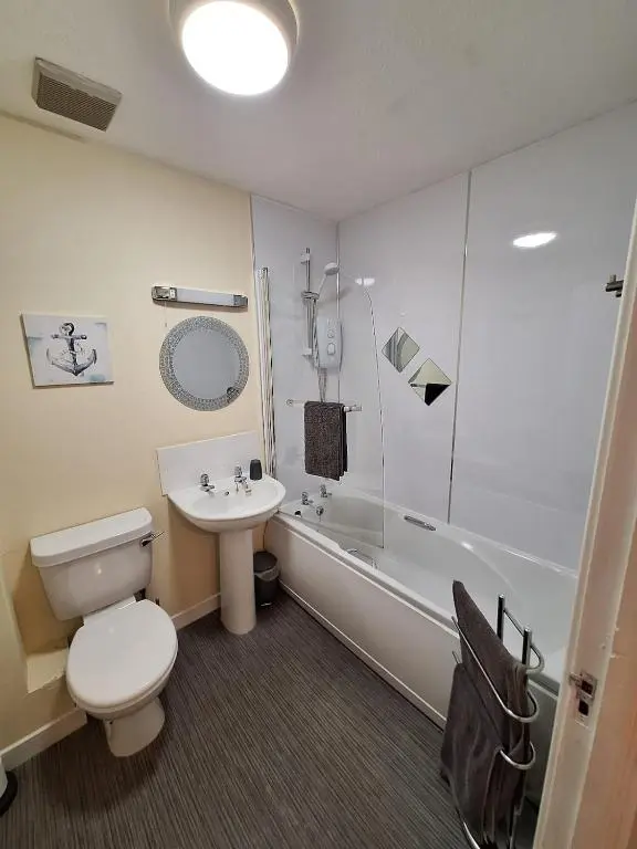 a bathroom with a toilet and a sink and a tub at Inverness City Centre Apartment! in Inverness