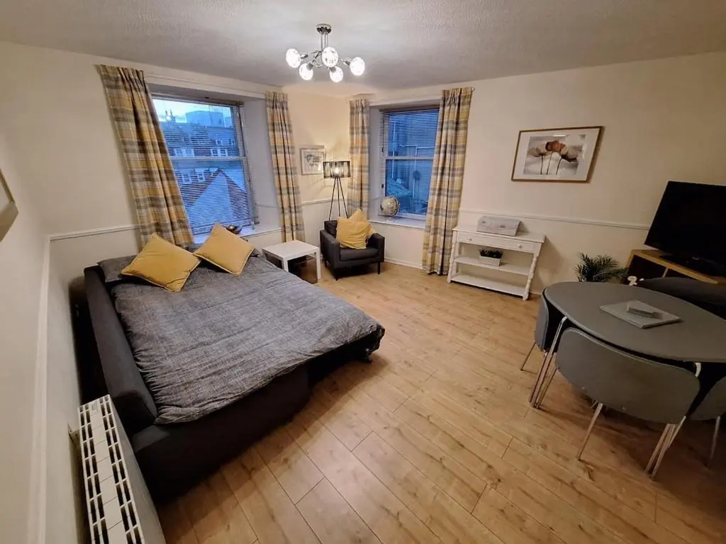 a bedroom with a bed and a table and a desk at Inverness City Centre Apartment! in Inverness