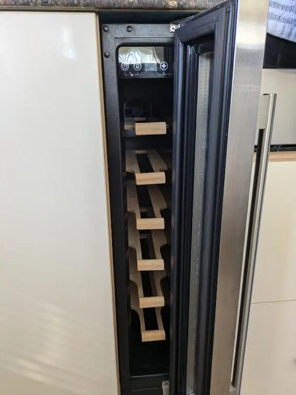 a refrigerator with its door open with wooden shelves at Dune Haven Luxury Beachside Lodge in Lossiemouth