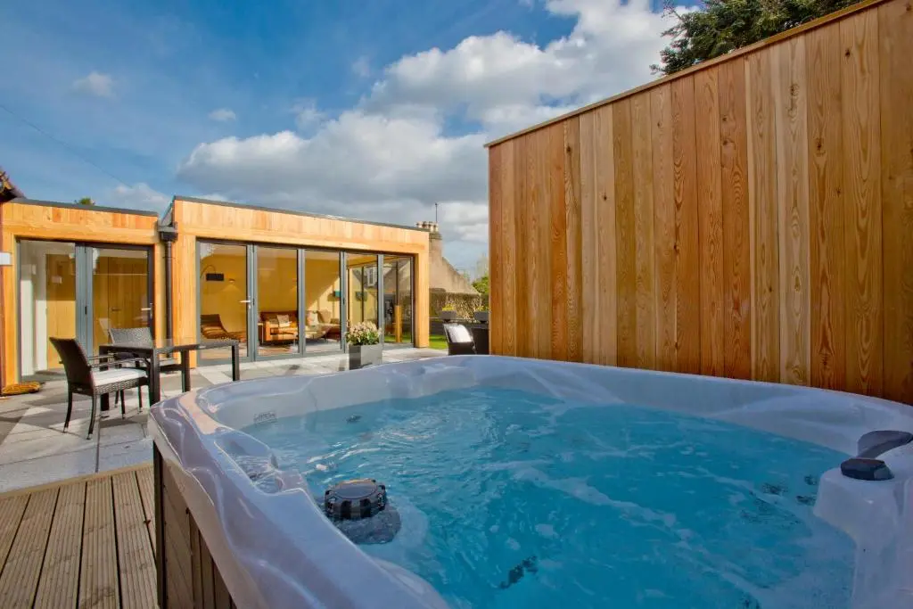 a jacuzzi tub on the deck of a house at The Invergarry - Royal Deeside Luxury 5 star Couples Retreat with Hot Tub, Aboyne in Aboyne