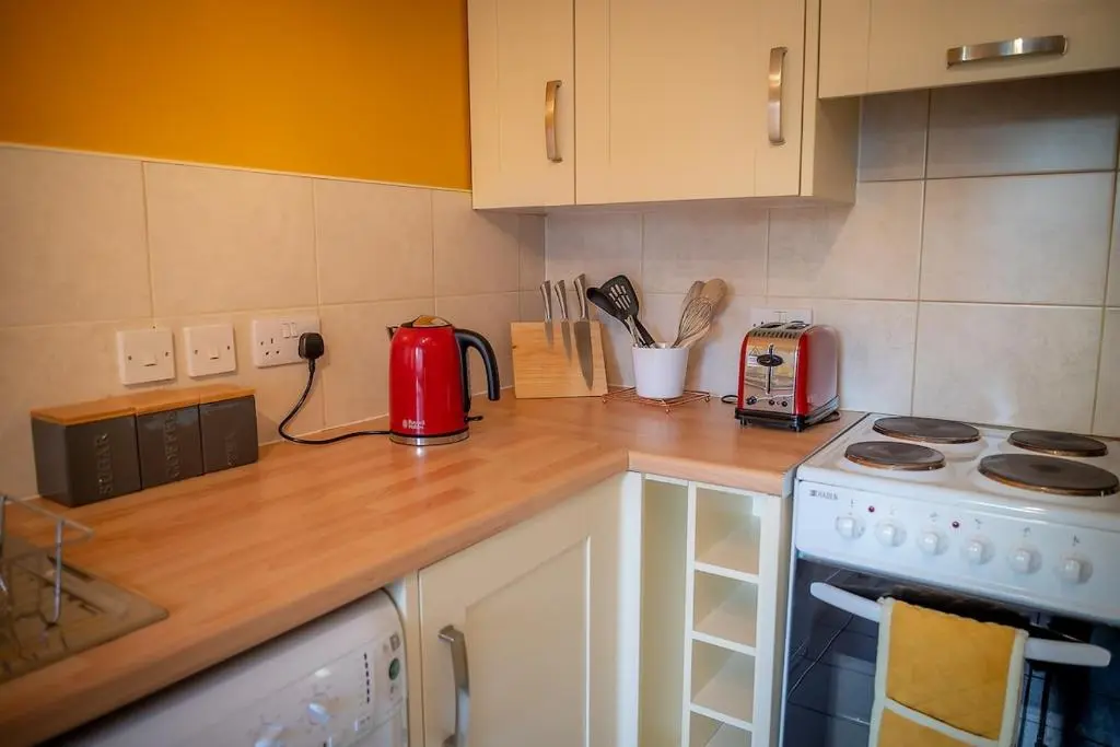 a kitchen counter top with a red appliance on it at Cosy fisherman cottage in seaside village in Shandwick