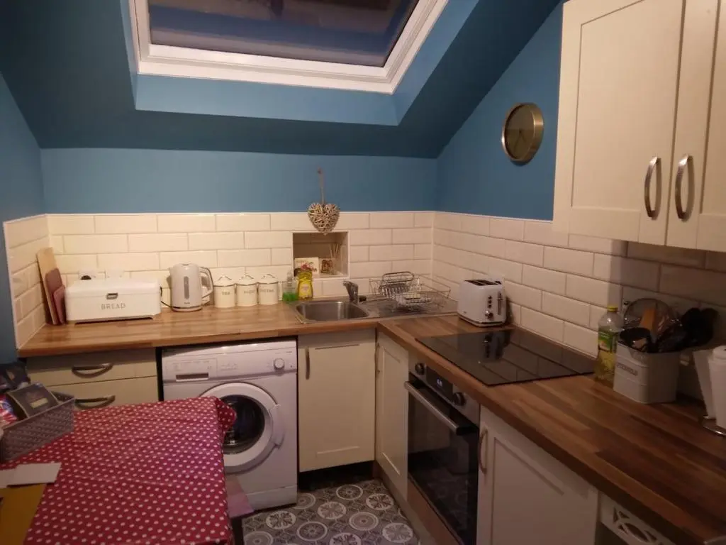 a kitchen with a sink and a washing machine at Cosy central 1 bedroom apartment, free parking in Inverness