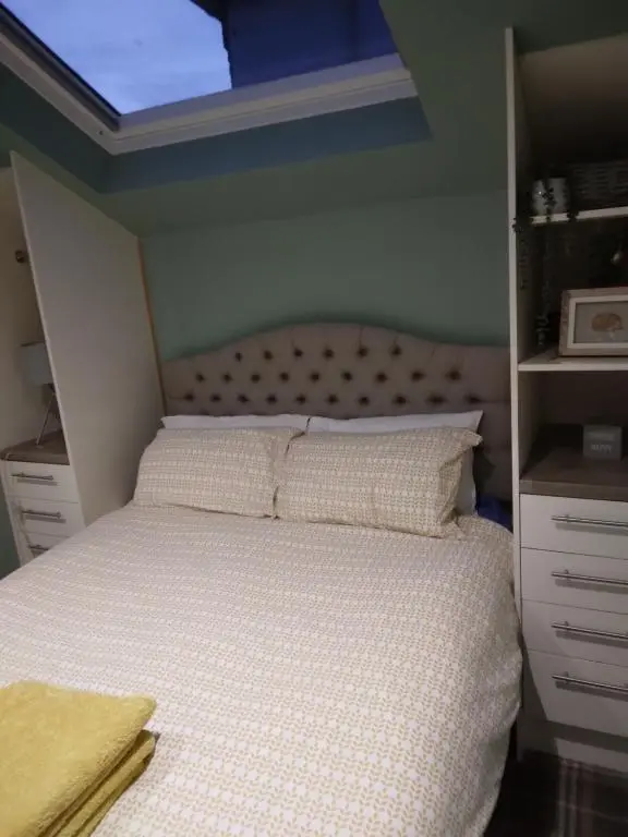 a bedroom with a bed with a window above it at Cosy central 1 bedroom apartment, free parking in Inverness