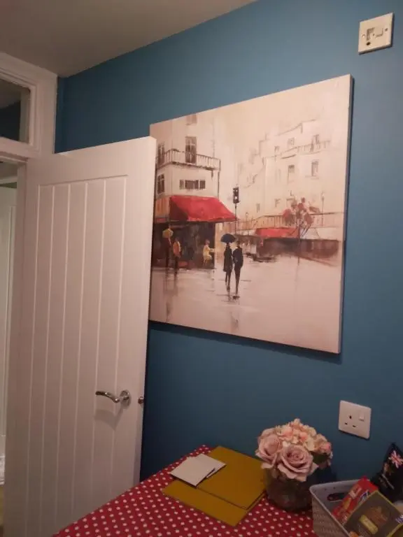 a painting on the wall of a room with a table at Cosy central 1 bedroom apartment, free parking in Inverness