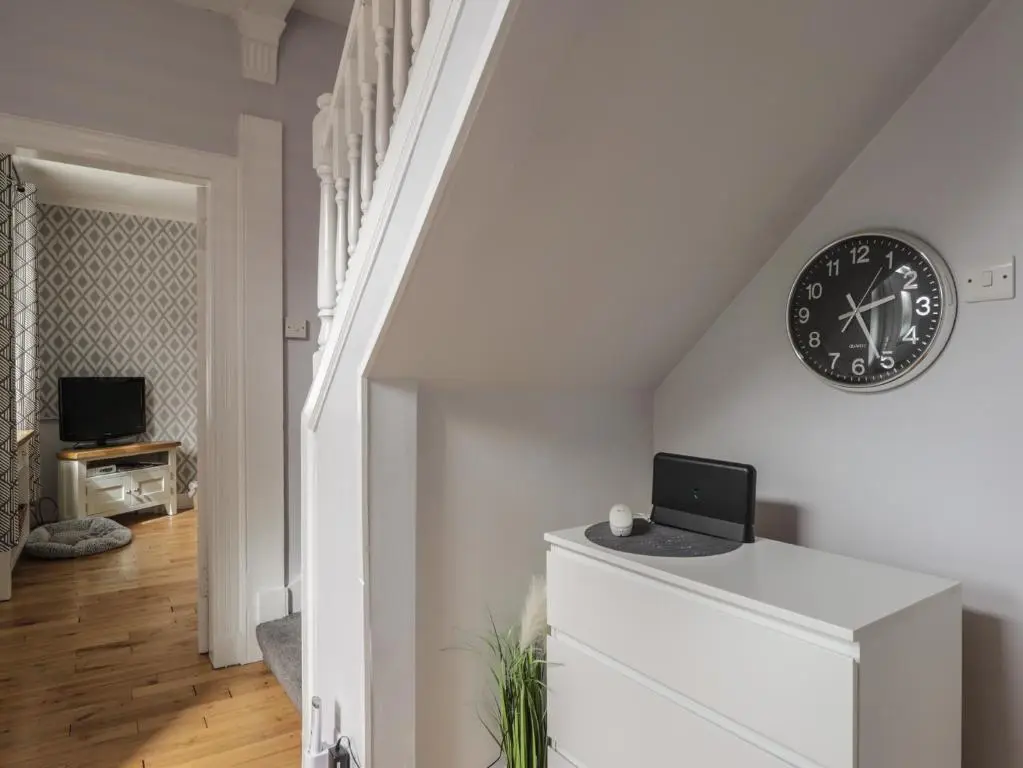 a white staircase with a clock on the wall at 6 New Street in Elgin