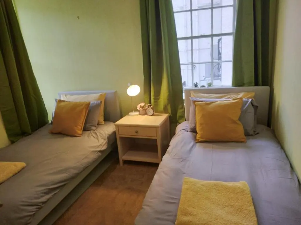 two twin beds in a room with a window at Cosy central 2 bedroom apartment - free parking in Inverness
