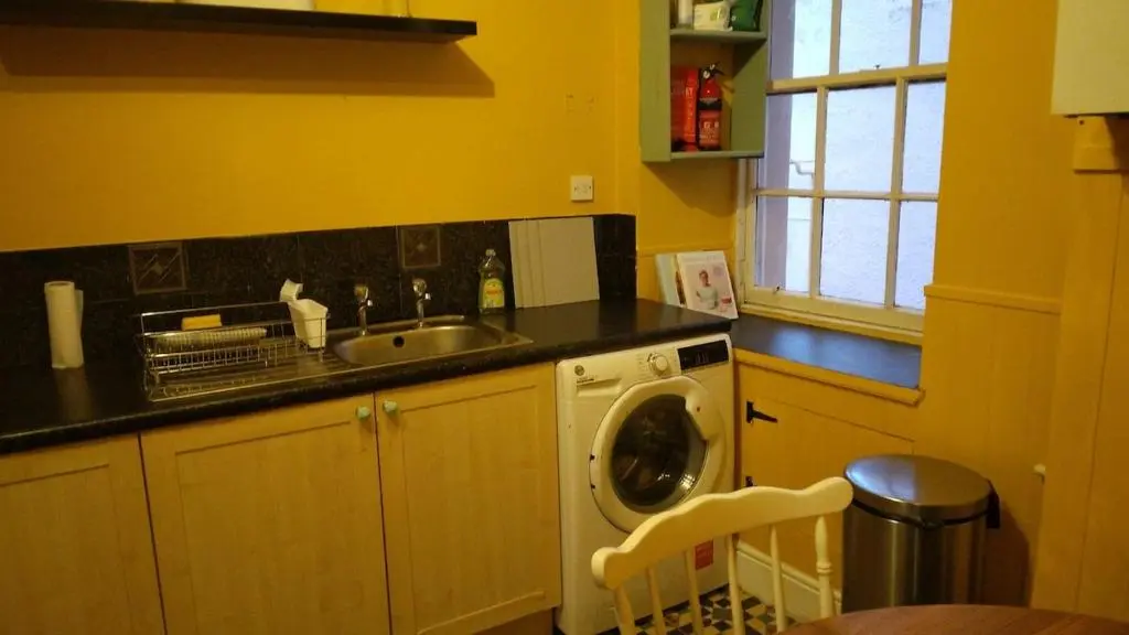 a kitchen with a sink and a washing machine at Cosy central 2 bedroom apartment - free parking in Inverness