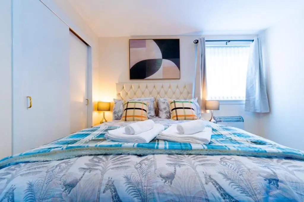 a bedroom with a bed with towels on it at Lovely & Bright 2 Bed Apartment in Inverness