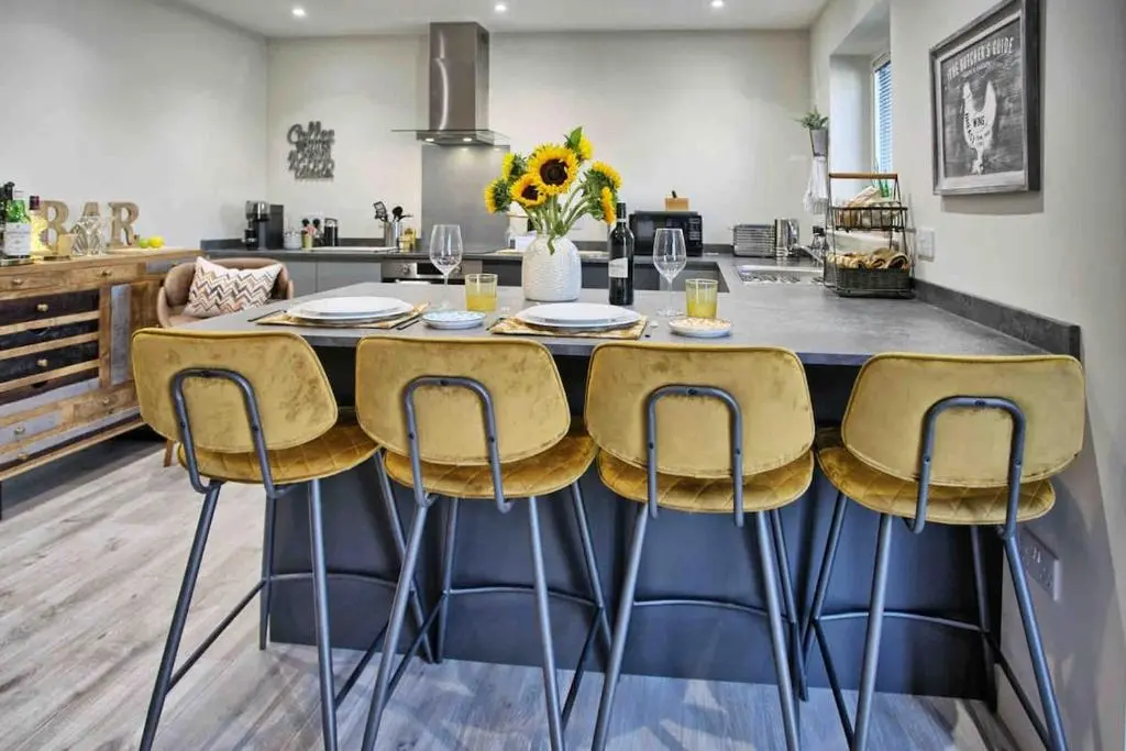 a kitchen with a large table with yellow chairs at Luxury Apartment Alford Aberdeenshire in Alford