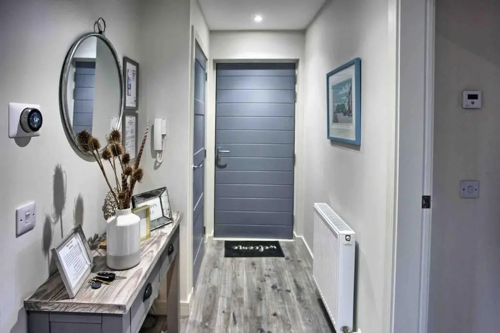 a hallway with a blue door and a mirror at Luxury Apartment Alford Aberdeenshire in Alford