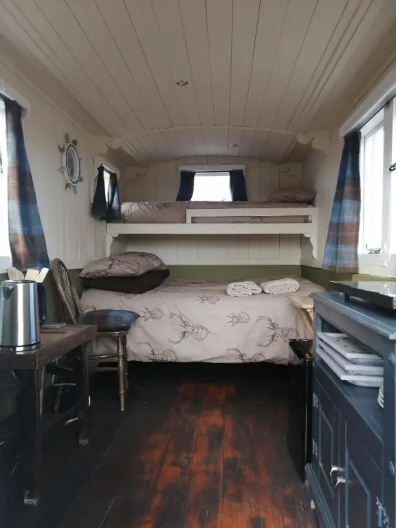a small room with a bed and a table at The Cairn Hut in Lybster