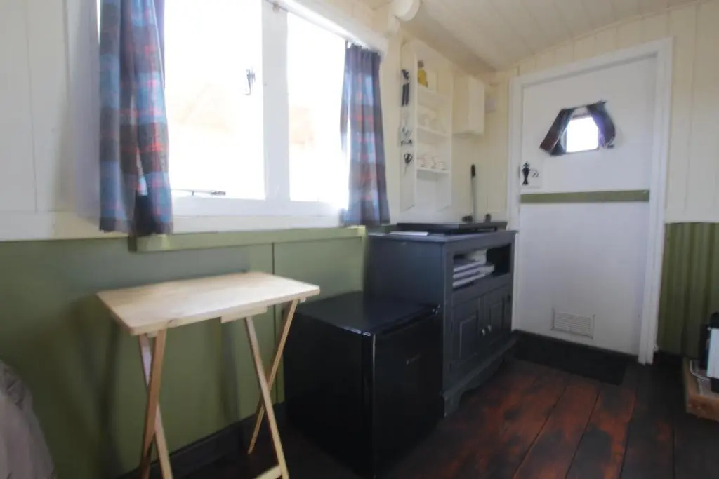 a small kitchen with a black cabinet and a window at The Cairn Hut in Lybster