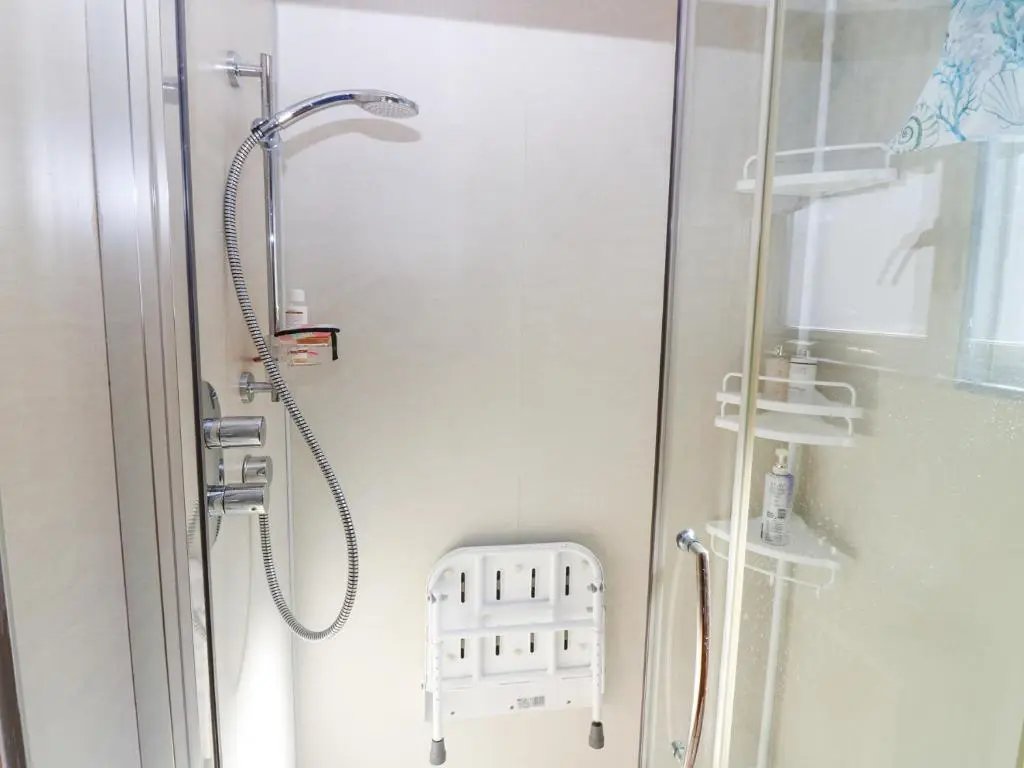 a shower in a bathroom with a glass door at Periwinkle Cottage in Banff