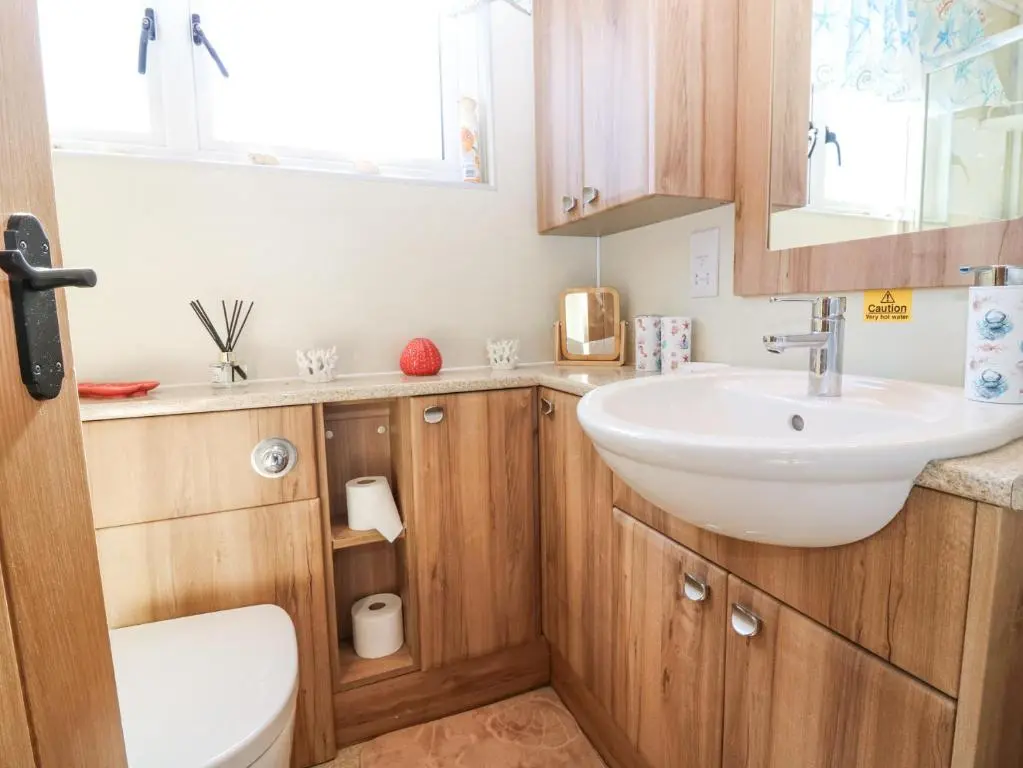 a bathroom with a sink and a toilet at Periwinkle Cottage in Banff