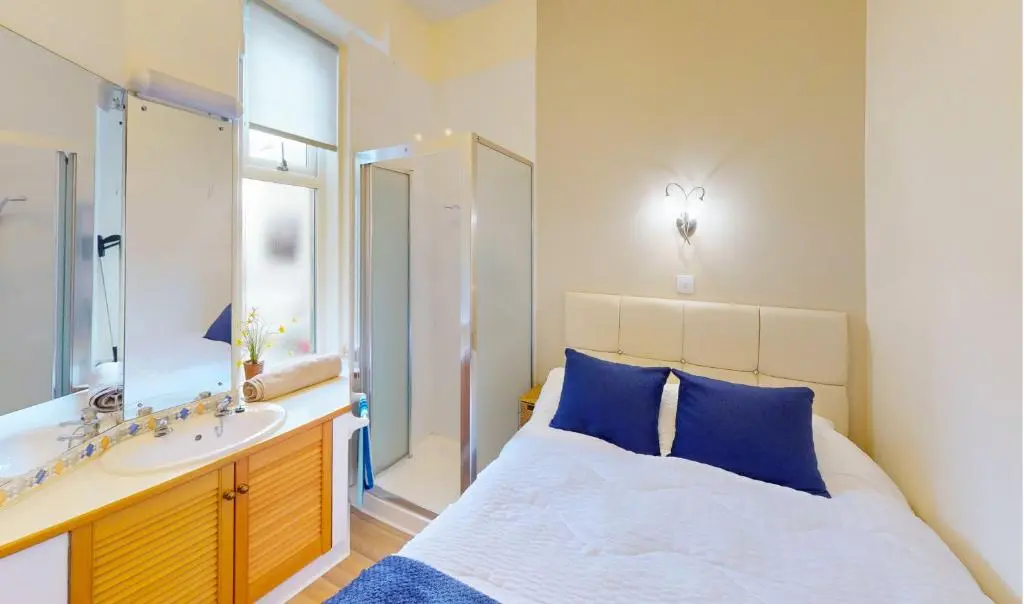 a bedroom with a large bed and a sink at Birchview in Aviemore