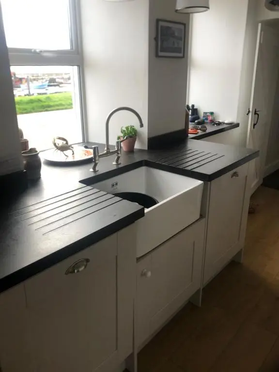 a kitchen with a white sink and a window at The Hoose in Helmsdale