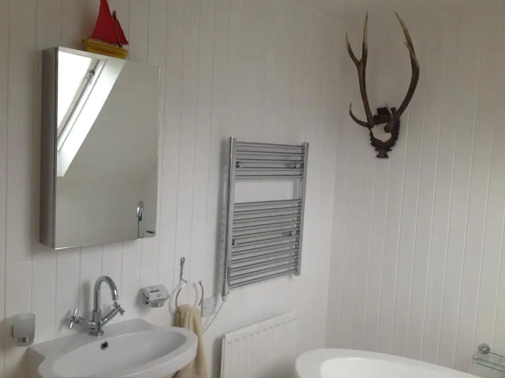 a bathroom with a sink and a mirror at The Hoose in Helmsdale