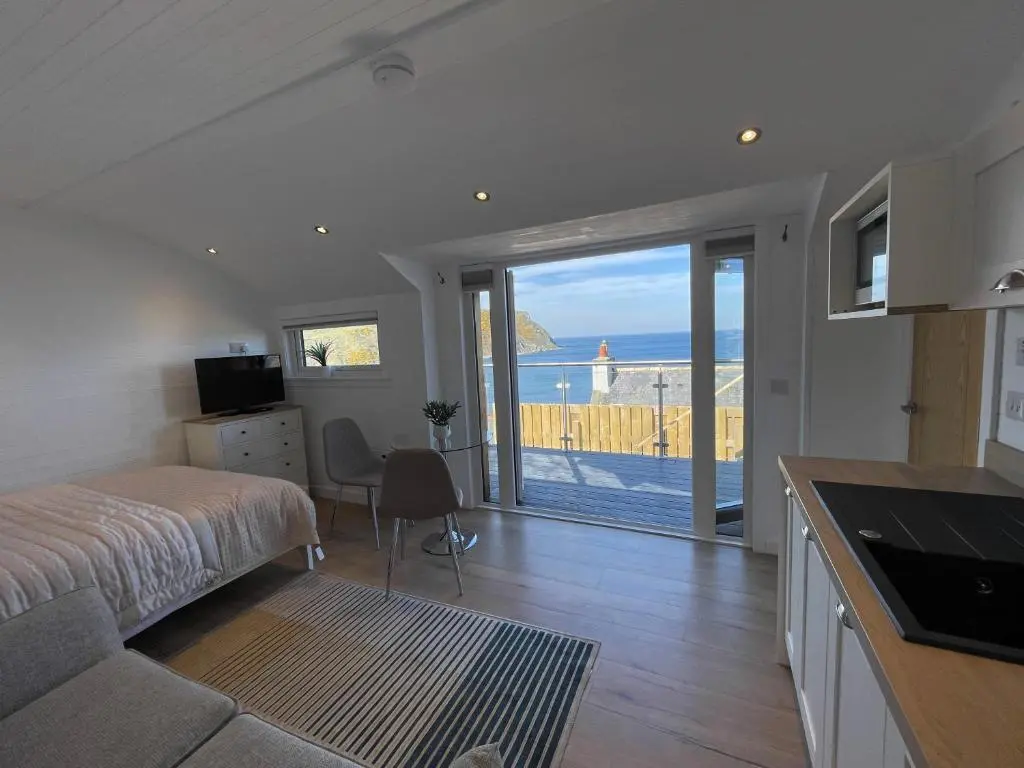 a bedroom with a bed and a view of the ocean at Gamrie Beach Bothy in Gardenstown