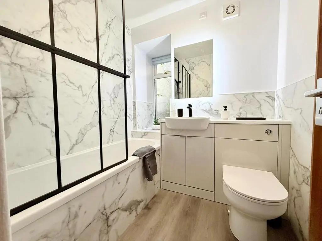 a white bathroom with a toilet and a sink at Sea Breeze Cottage short walk to the beach, Nairn in Nairn