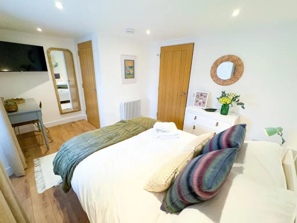 a bedroom with a white bed with pillows on it at The Lookout, Lossiemouth in Lossiemouth