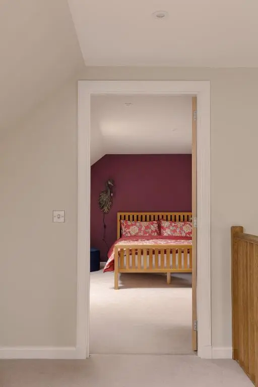 a bedroom with a bed with red walls at Elrick Estate - Coach House in Newmachar