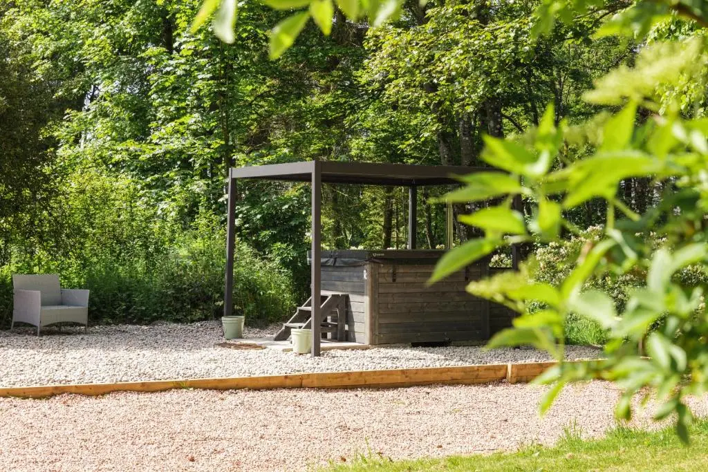 a barbecue under an umbrella in a garden at Elrick Estate - Coach House in Newmachar