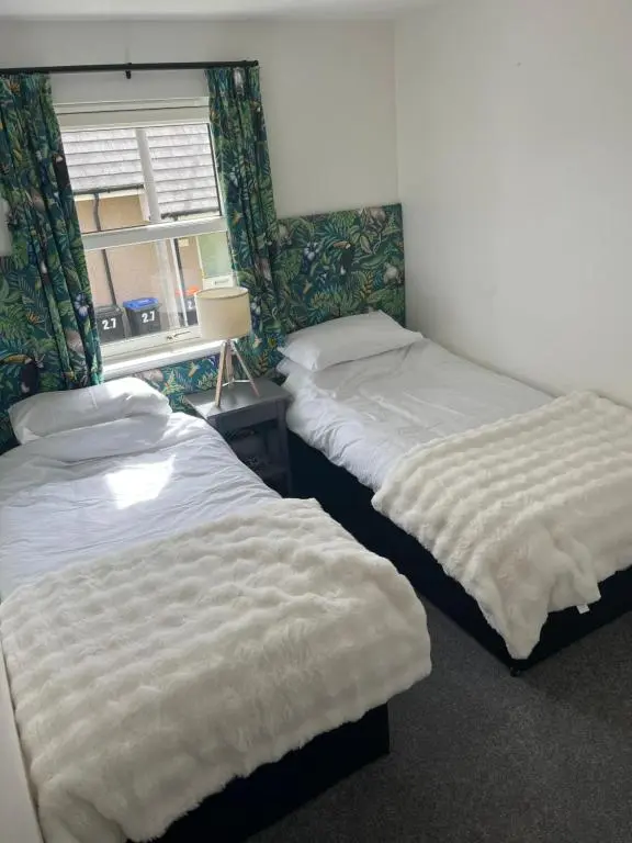 two twin beds in a room with a window at Inchmarlo Villa 29 Banchory in Inchmarlo