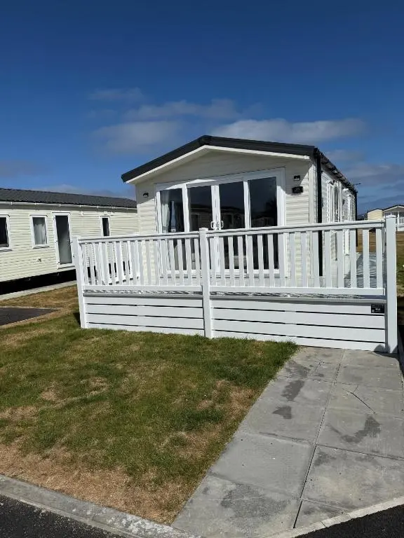 a white mobile home with a white fence at 36 Lighthouse View in Lossiemouth