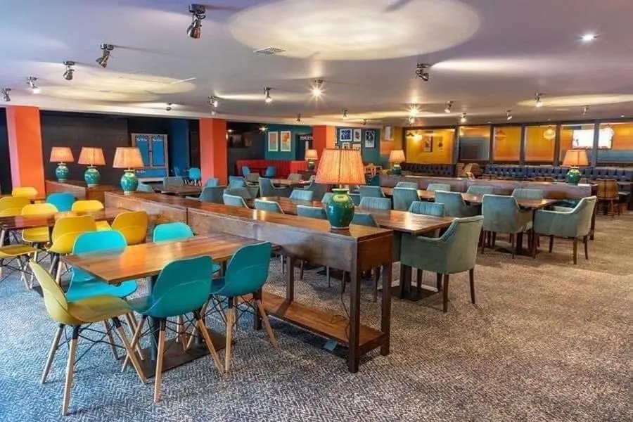 a cafeteria with tables and chairs in a room at 36 Lighthouse View in Lossiemouth