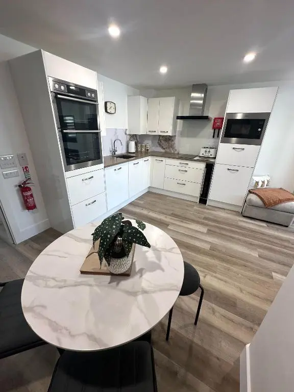 a large kitchen with a white table and a table and chairs at St\u0101 by The Bridge, Inverness City Centre in Inverness