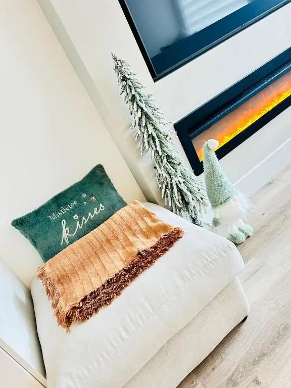 a white couch with a pillow and a christmas ornament at St\u0101 by The Bridge, Inverness City Centre in Inverness