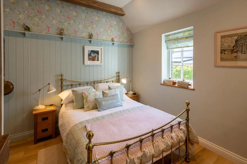 a bedroom with a bed and a wall with flowers at Bridgend Bothy in Drumnadrochit