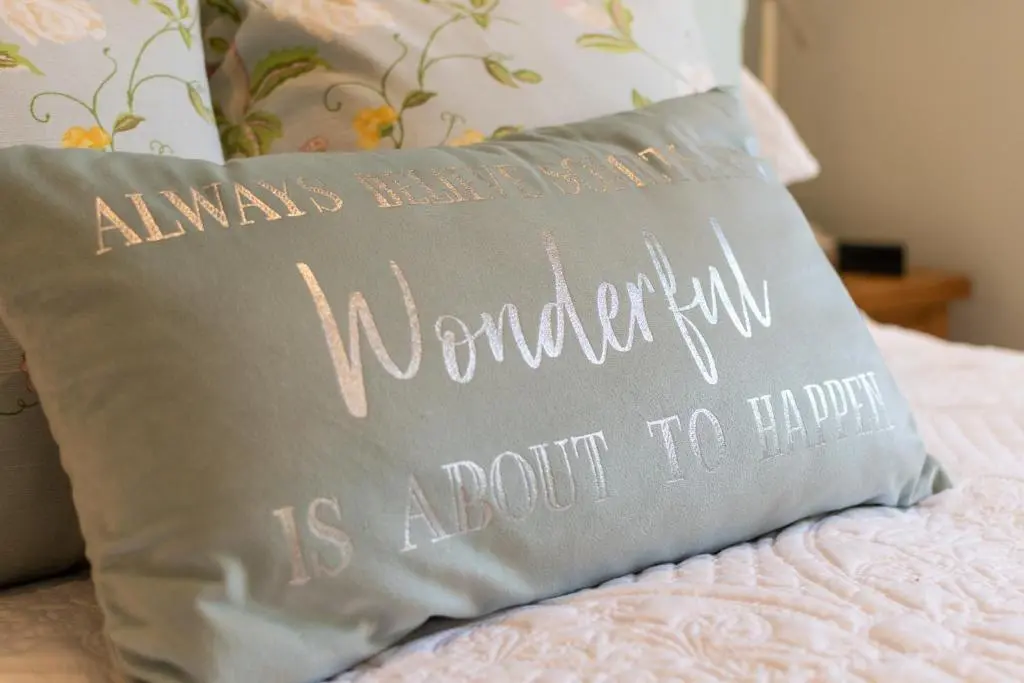 a pillow on a bed with the wordsremember is about to happen at Bridgend Bothy in Drumnadrochit