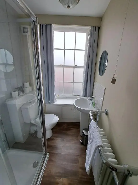 a bathroom with a shower and a toilet and a sink at Cosy Riverside Apartment with free parking in Inverness