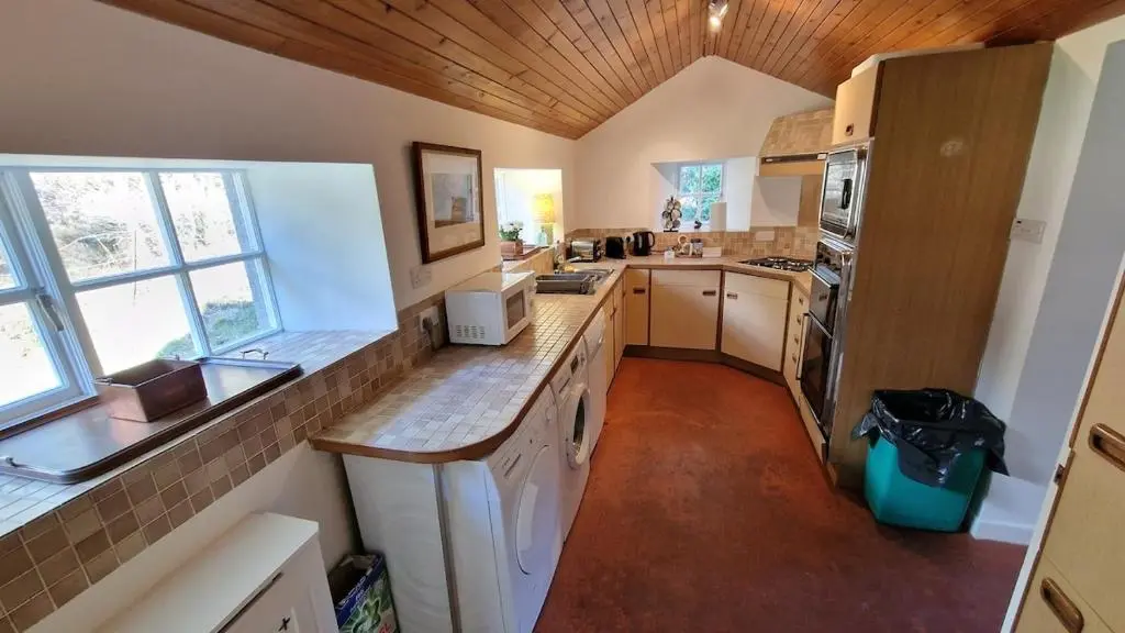 a kitchen with a sink and a stove top oven at Garden Cottage in Cambus O\u02bcMay Station