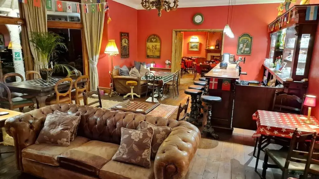 a living room with a couch and a table and chairs at Garden Cottage in Cambus O\u02bcMay Station