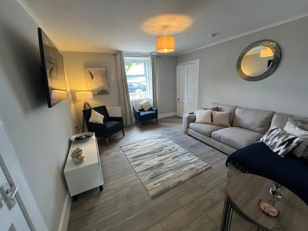 a living room with a couch and a table at 2 Links Place in Nairn