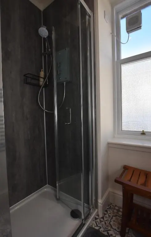 a shower with a glass door in a bathroom at The MacKenzie Apartment in Beauly