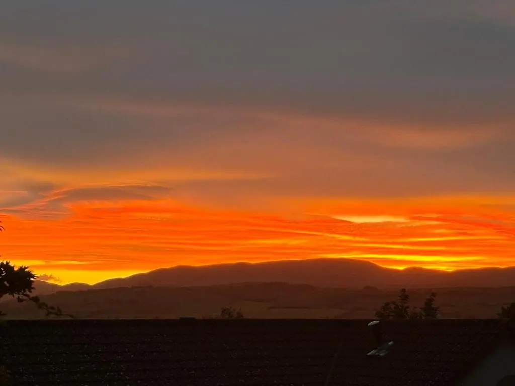 a sunset in the sky with mountains in the background at Danian B&B in Dingwall