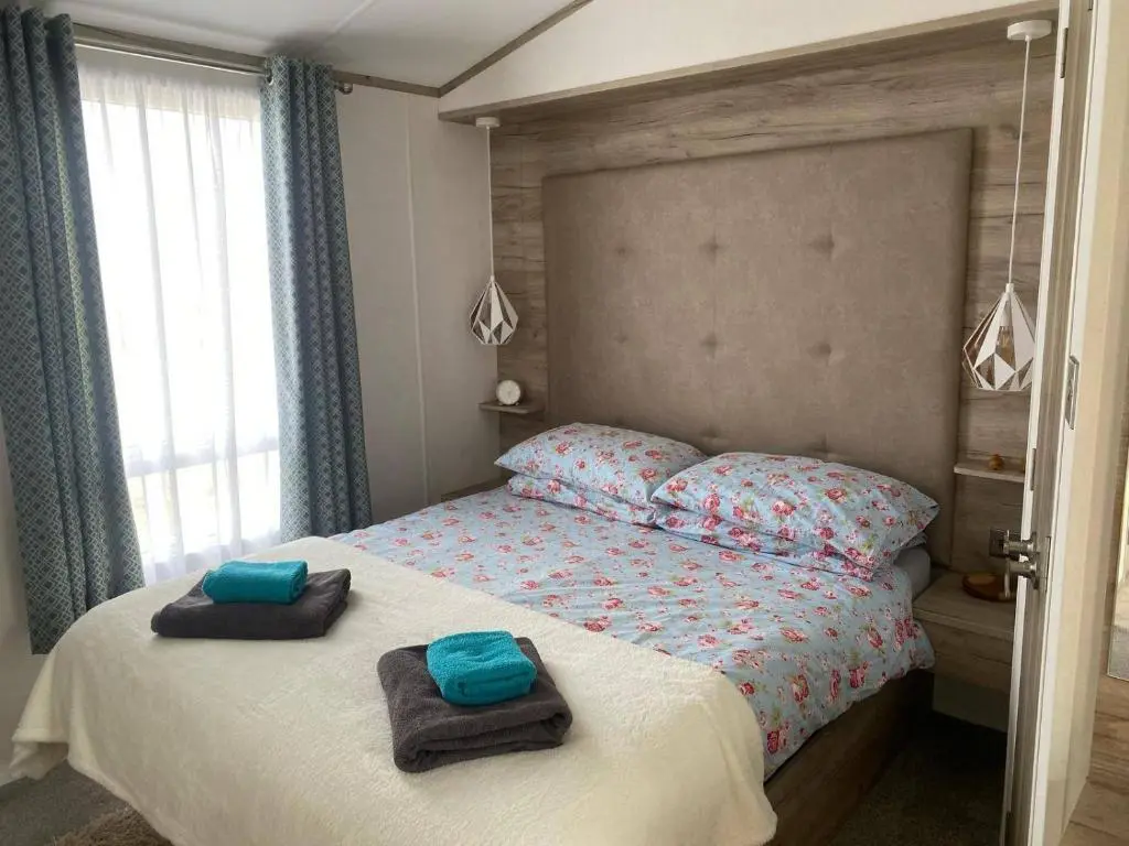 a bedroom with a bed with towels on it at Findhorn Lodge - Peaceful - Pets - Sleeps 4 in Forres