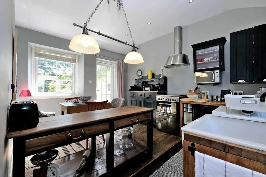 a kitchen with a wooden table in a room at West Manse in Inverurie