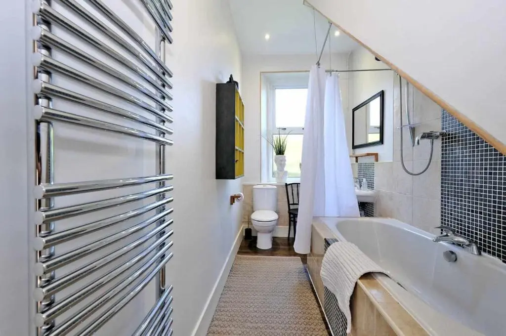 a bathroom with a tub and a toilet and a sink at West Manse in Inverurie