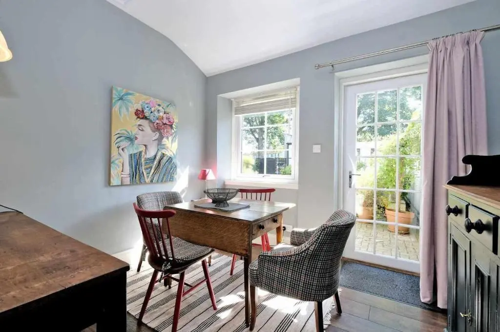 a dining room with a table and chairs and a window at West Manse in Inverurie