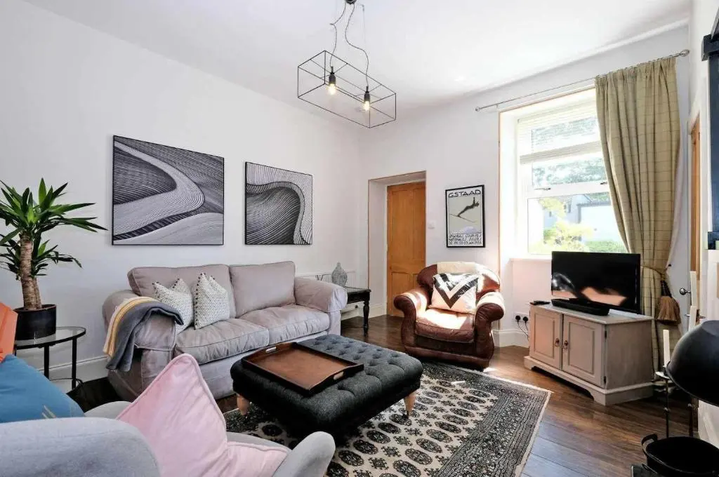 a living room with a couch and a tv at West Manse in Inverurie