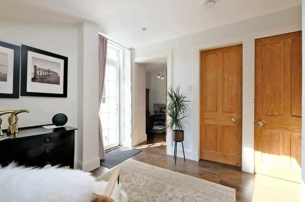 a living room with a wooden door and a living room at West Manse in Inverurie